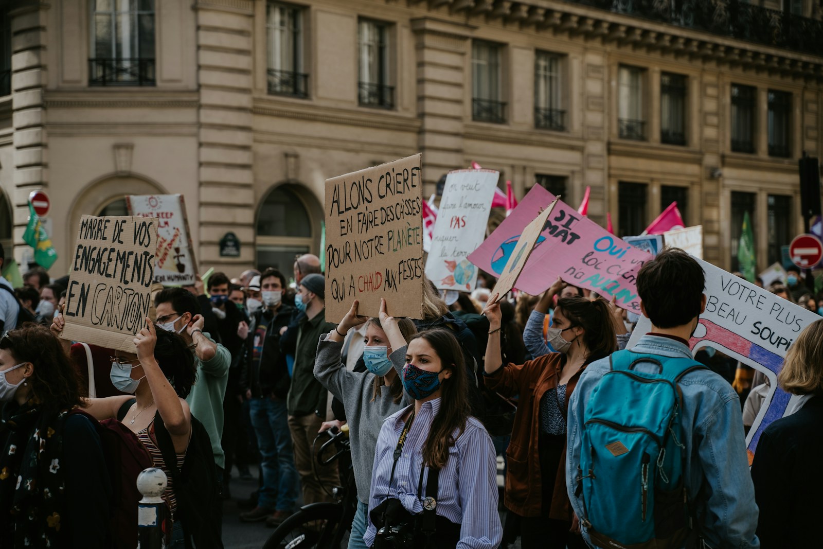 Jovens com cartazes numa manifestação numa rua de Paris